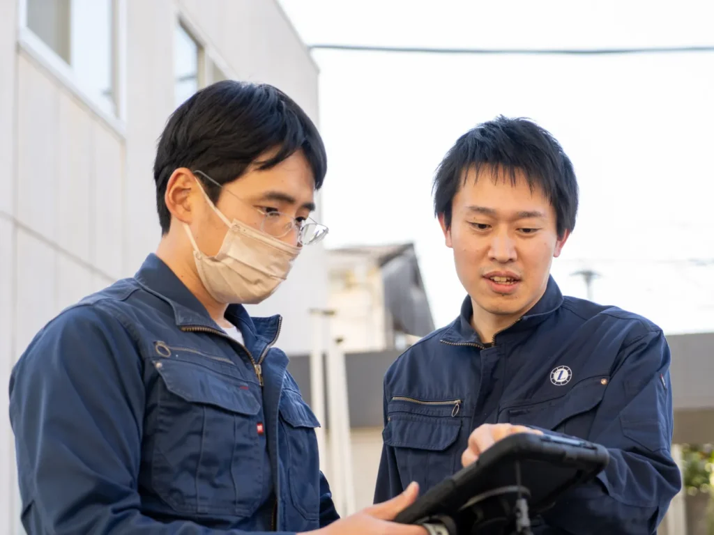 同僚とタブレットをながら打ち合わせをしている様子